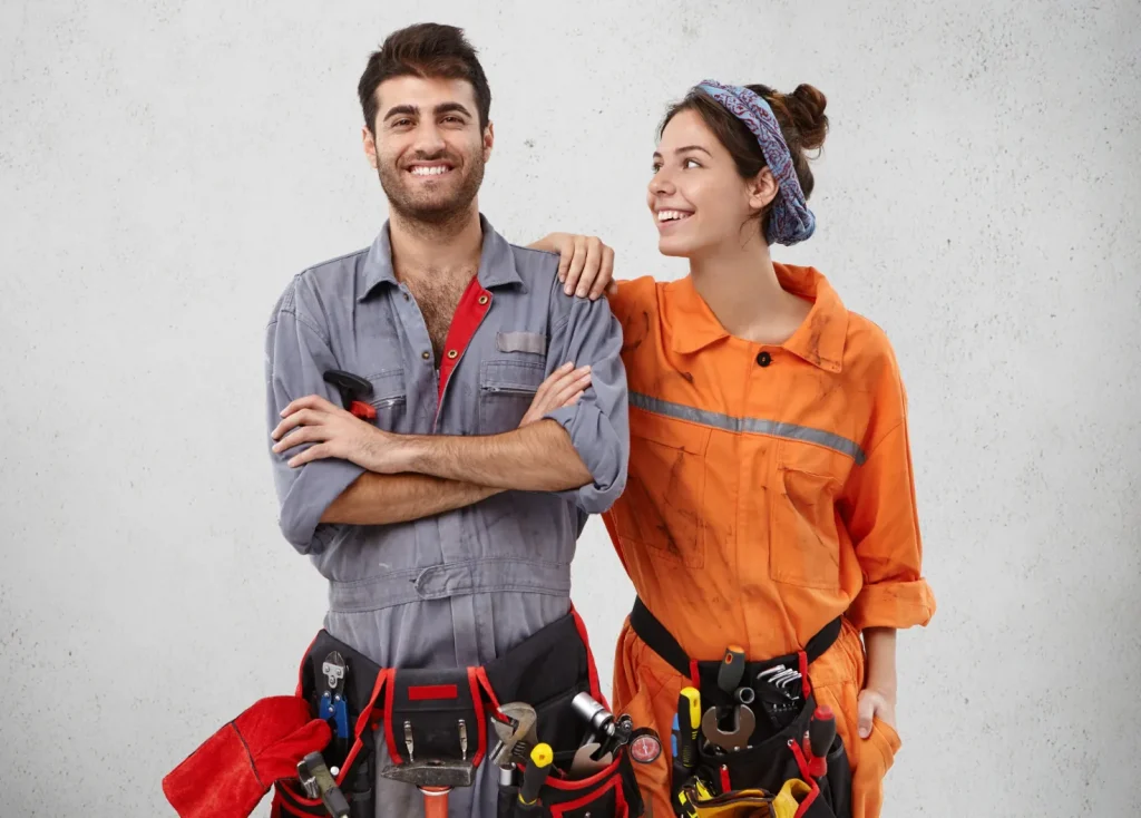 Un couple souriant en vêtement de travail pour rénover ma maison